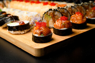 Maki rolls with salmon and tobiko calve. Set of rolls on blurred background.