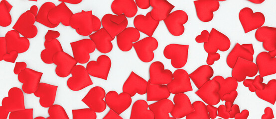 Banner with texture made of red confetti in a heart shape on a blue background.