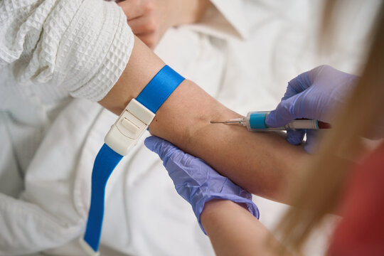 Doctor giving intramuscular injection in female arm
