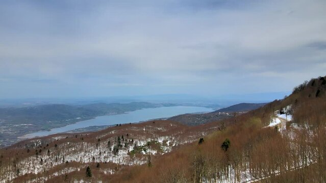 Kartepe Kocaeli TURKEY aerial view from mountain rising camera snow covered forest and Lake Sapanca visible at lower level in April 2023