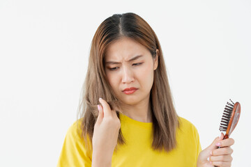 Asian woman very sad and upset looking at damaged hair, hair loss, hair thinning problem, vitamin...