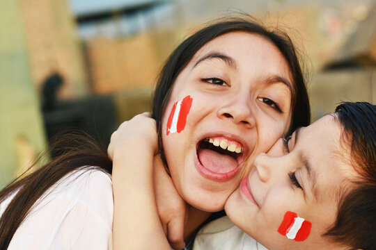 Happy peruvian kids with colors of peruvian flag on the cheek.