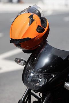 orange motorcycle helmet on the handlebar