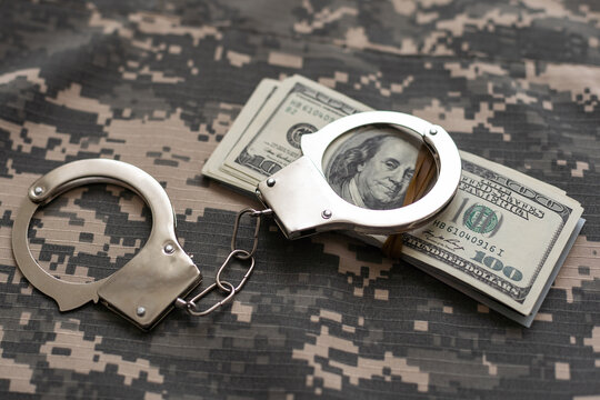 military uniform and handcuffs, money. War criminal, criminal liability of military personnel, bribe taker