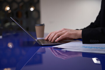Man in suit typing on laptop close-up