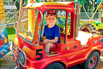 Obraz na płótnie Canvas little boy on a car carousel