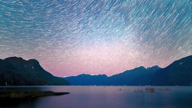 sunset over the lake with time-lapse of moving stars