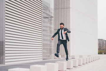 Energetic young bearded professional businessman jumping in mid-air