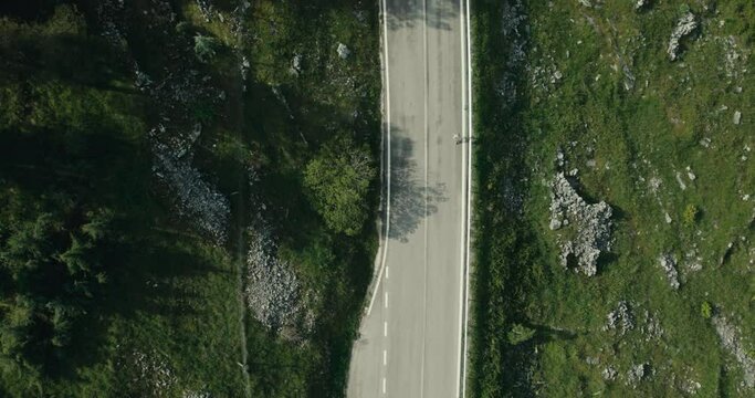 Zenithal aerial of a woman running down a mountain road in Abruzzes Italy