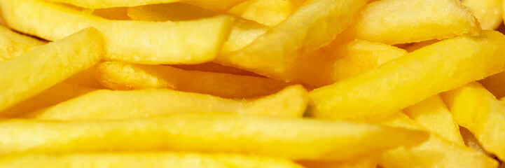 Fresh tasty fried french fries in sunlight close up. Banner. Selective focus, defocus