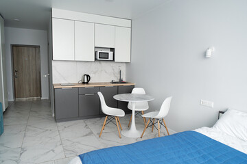 Modern interior of tiny studio appartment. Modern bedroom and kitchen in tiny home. - obrazy, fototapety, plakaty