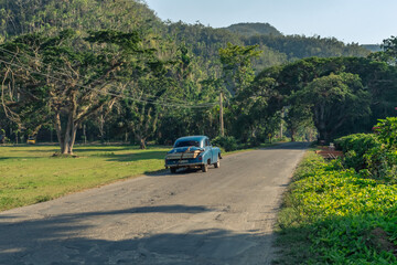 Old American car driving in the countryside near Vinales in Cuba