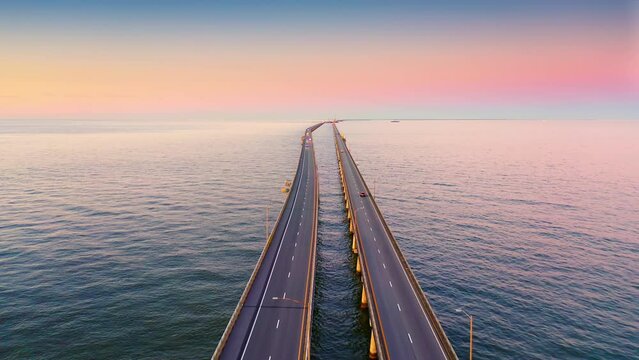 Aerial view of Chesapeake Bay Bridge Tunnel at sunset with backward camera motion. CBBT is a 17.6-mile bridge tunnel that crosses the mouth of the Chesapeake Bay.