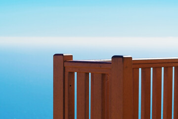 Close-up of a wooden banister at a viewpoint overlooking the Mediterranean sea