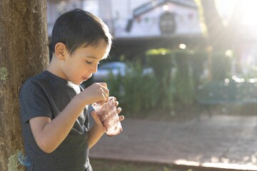Young boy eating Acai frozen ice cream treat in summer
