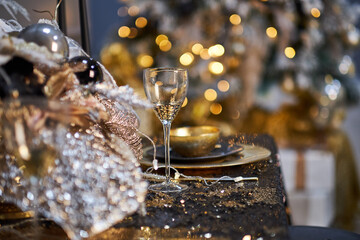 Christmas table setting with plates, silverware, gift box and decorations in black and gold colors