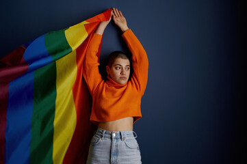 Portrait of young lesbian woman holding lgbtq flag performing for sexual freedom