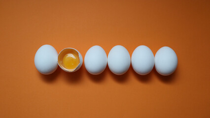 Row White eggs and egg yolk on the yellow background.