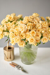 Floral carpet, flower texture, shop concept. Beautiful fresh blossoming flowers roses, spray roses. Blossom of pastel color in vases and pails. Top view.