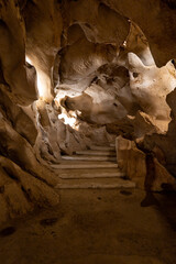a vertical shot of natural cave with walkways, stairs and lighting offering guided tours