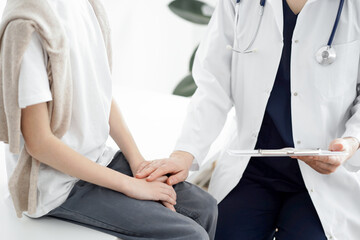 Doctor and child patient. The physician is holding clipboard and reassuring a boy. The concept of ideal health in medicine.