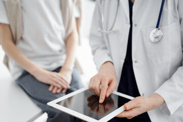 Doctor and child patient. The doctor is using tablet computer and is ready to examine the boy. The concept of ideal health in medicine.