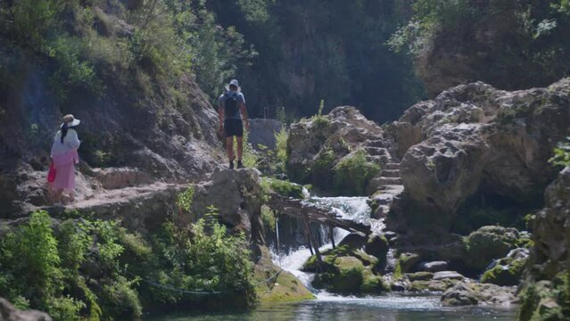 Couple crossing river, Akchour Falls, Morocco 4k 50fps