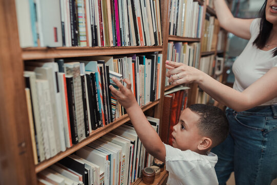Child looking for a book on the shelves at home