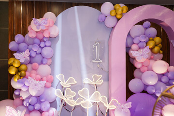 First birthday or anniversary decoration with a pastel pink, purple set up with balloons,...
