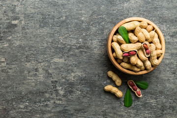Fresh healthy peanuts in bowl on colored table background. Top view Healthy eating bertholletia concept. Super foods
