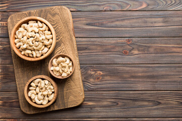 cashew nuts in wooden bowl on table background. top view. Space for text Healthy food