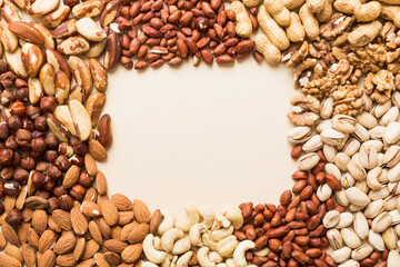 different nuts frame background. Close up, top view, flat lay with vopy space. Walnut, pistachios, almonds, hazelnuts and cashews