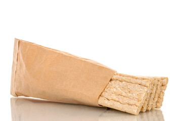 Several rye crispbreads in a paper bag, macro, isolated on a white background.