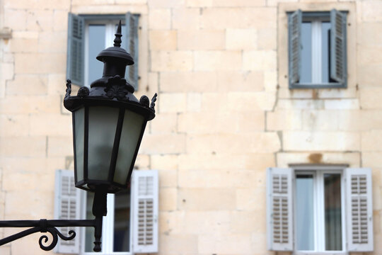 Fototapeta Vintage cast iron street lamp and traditional Mediterranean windows. Selective focus. 