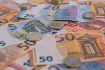 View of euros bank notes and coin. Bank notes of twenty, fifty, ten and five euros as well as one and two euros coins are seen piled up