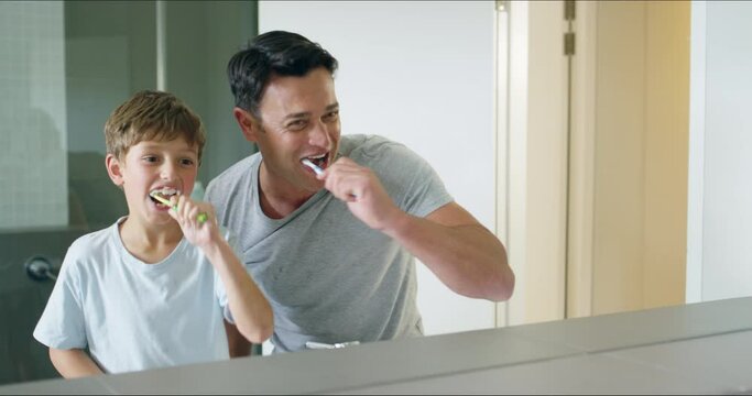 Father, child and brushing teeth, dancing in mirror and happiness in the bathroom. Dad, kid and dance with toothbrush, bonding and cleaning for oral health, dental wellness and learning hygiene.