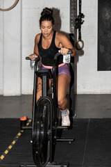 Fototapeta na wymiar Pedaling to Fitness: A Latina Woman's Determination Shines in the Gym's Indoor Cycling Session