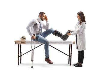 Obraz premium Female doctor putting on a walking brace to a male patient