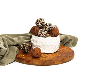 Energy balls in white bowl. Healthy raw dessert, vegetarian truffles, sugar free candies made of dates, hazelnuts, cocoa powder.