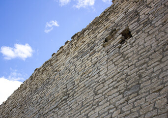 Fototapeta na wymiar Ancient ruined wall against the sky. Castle wall.Historical era wall.