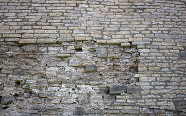 Old ruined stone wall. Ancient stones, structure with mold.