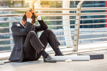 business man in suit frustrated he sad for lost work job sit on street upset fail unhappy after...