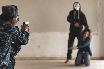 Police cop constable aiming handgun too attack terrorist thief robber with hostage in abandon...