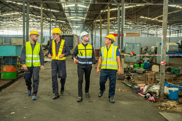 Group of engineer foreman walk line of troops straight in and talk together at end time of work in old Factory. unity teamwork colleague foreman and trainee walk straight in and talk collaboration.