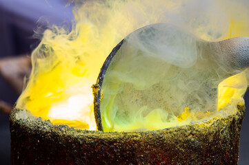 Old rural local Melt Gold pour into ingot mould. Pouring liquid gold into graphite casting form...