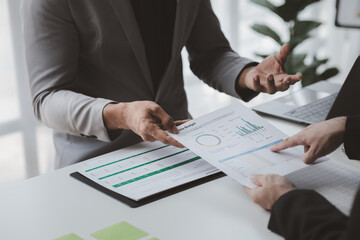 Two businessmen pointed to the material for the meeting, working together to plan to develop and solve common business problems. Concept of business management for growth and quality.