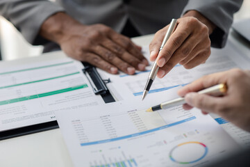 Two businessmen pointed to the material for the meeting, working together to plan to develop and solve common business problems. Concept of business management for growth and quality.