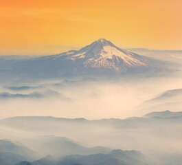 An aerial shot of Mt Hood with fog laying in the valleys surrounding the mountain, near Portland, Oregon.