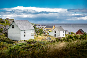 Fototapeta na wymiar East Coast homes on a rocky shoreline overlooking the Atlantic Ocean at Keels Newfoundland Canada.