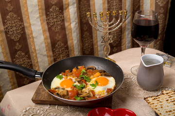 A set table and hot shakshuka in a frying pan.